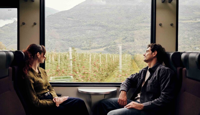 Zwei Personen fahren mit dem Zug durch Südtirol. | © IDM Südtirol-Alto Adige / Manuel Ferrigato