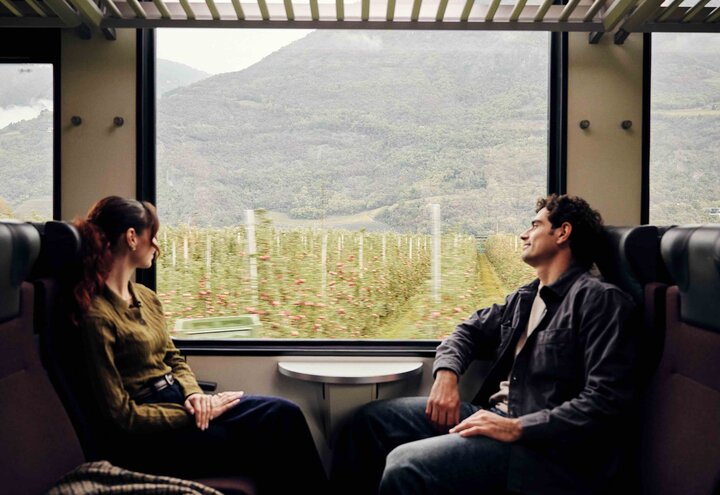 Zwei Personen fahren mit dem Zug durch Südtirol. | © IDM Südtirol-Alto Adige / Manuel Ferrigato